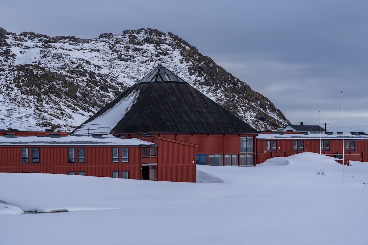 Where to Stay at the North Cape in Norway (+ Honningsvåg)
a red building in the snow with a cone shaped roof