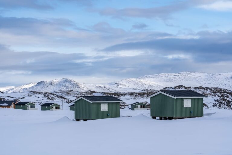 Where to stay at the North Cape and Honningsvåg travel guide Green cabins in the snow on a treeless landscape