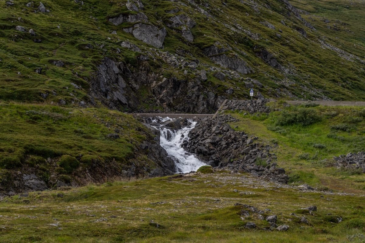 Where to Stay at the North Cape in Norway (+ Honningsvåg)
a small waterfall on the roadside in norway