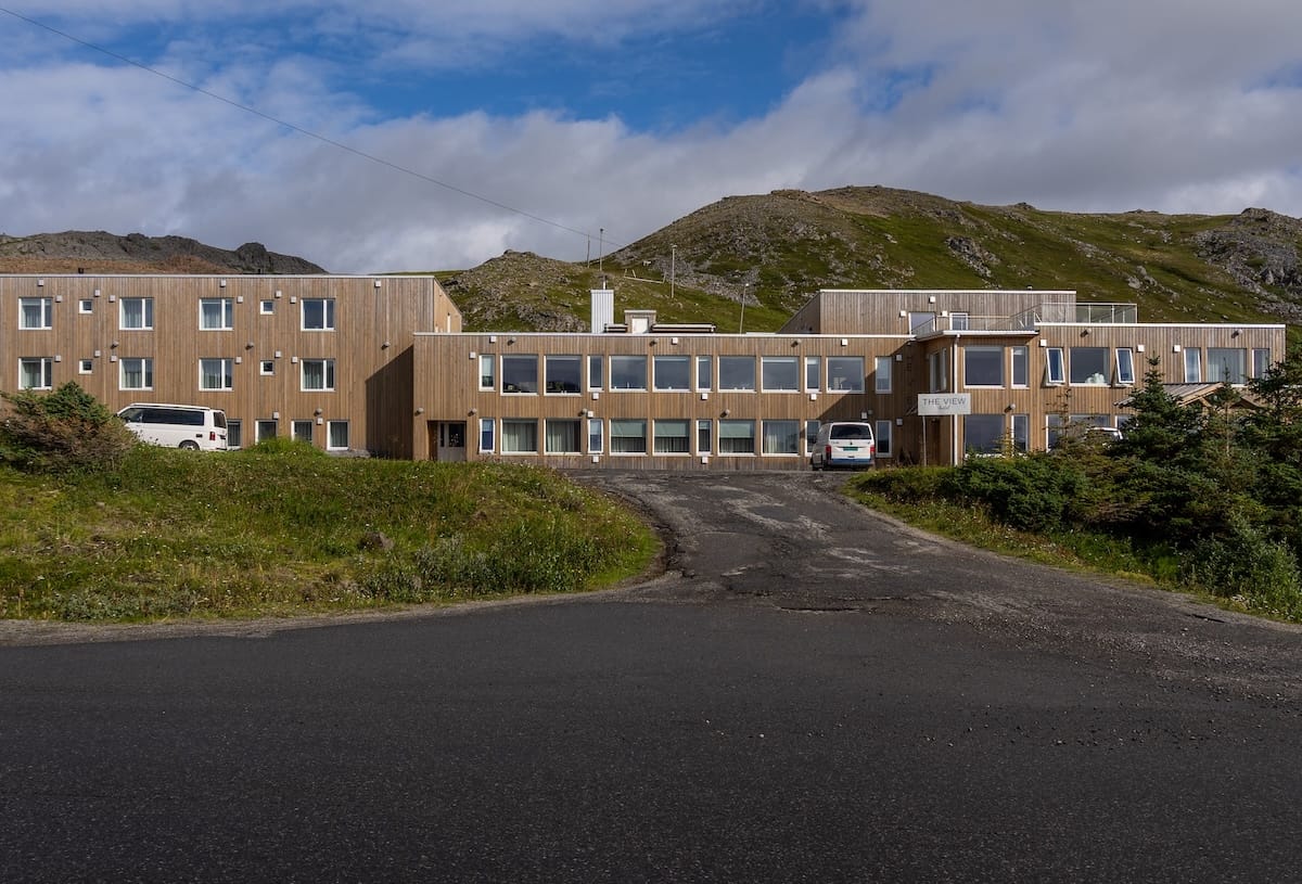 Where to Stay at the North Cape in Norway (+ Honningsvåg)
The outside of a hotel called The View - a grey/tan building with a mountain in the background