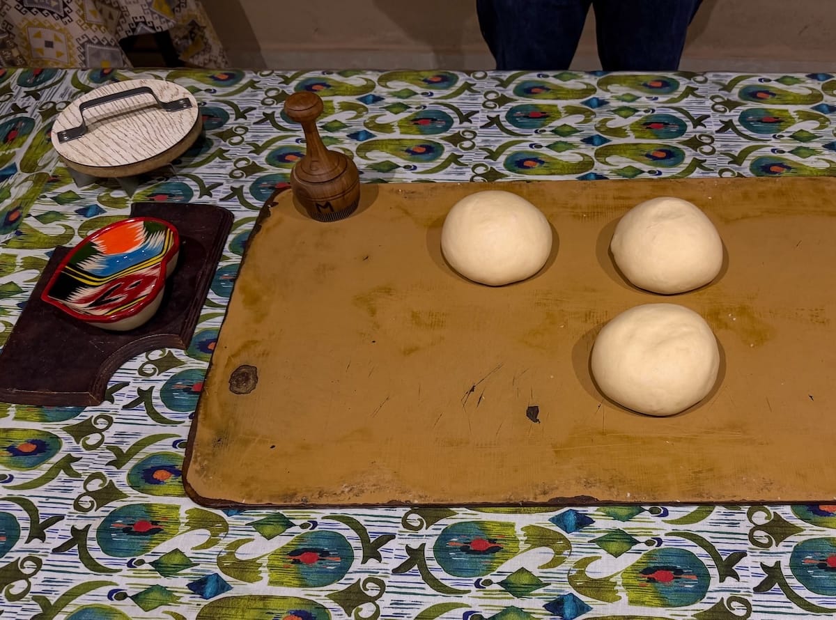 three portions of dough ready to be turned into bread on a table