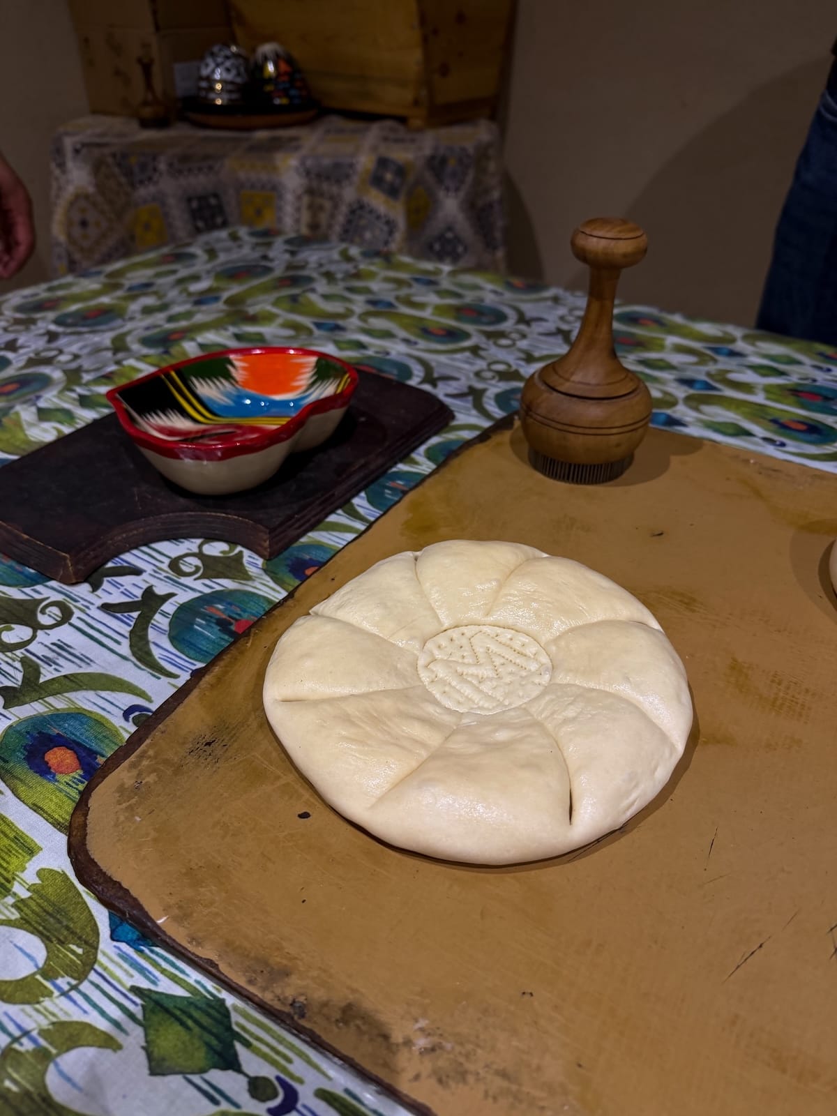 an uncooked bread with an 'M' in the center on a table