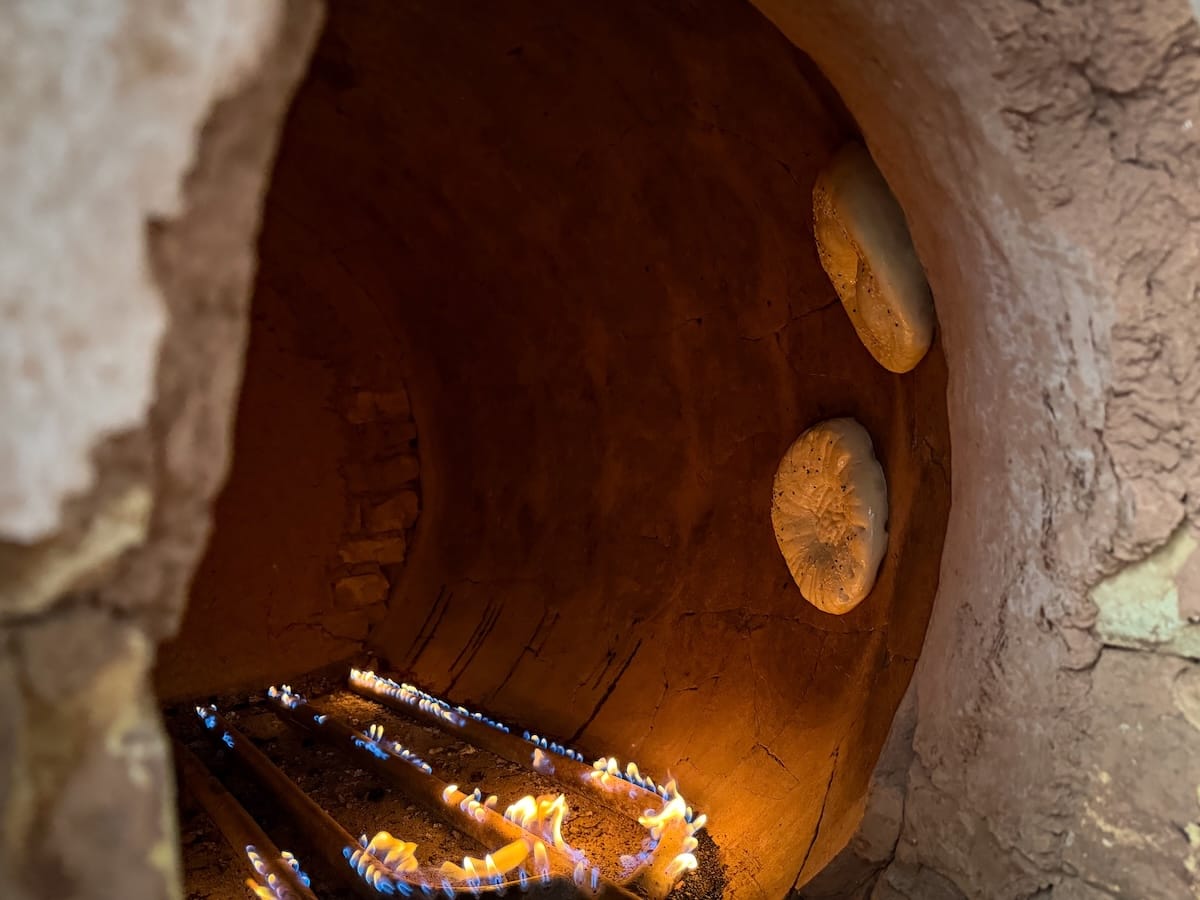two breads stuck inside a tandir in uzbekistan