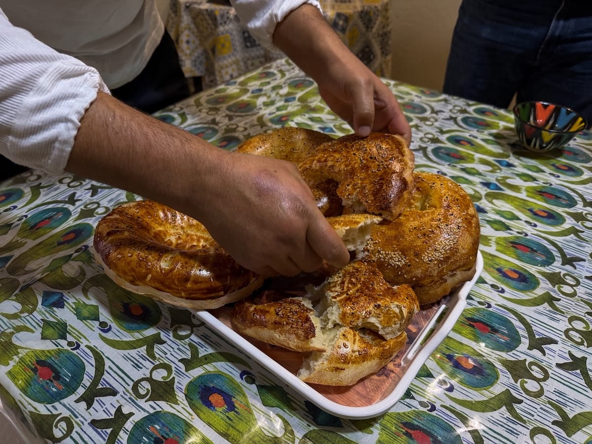 a man breaking apart pieces of bread
