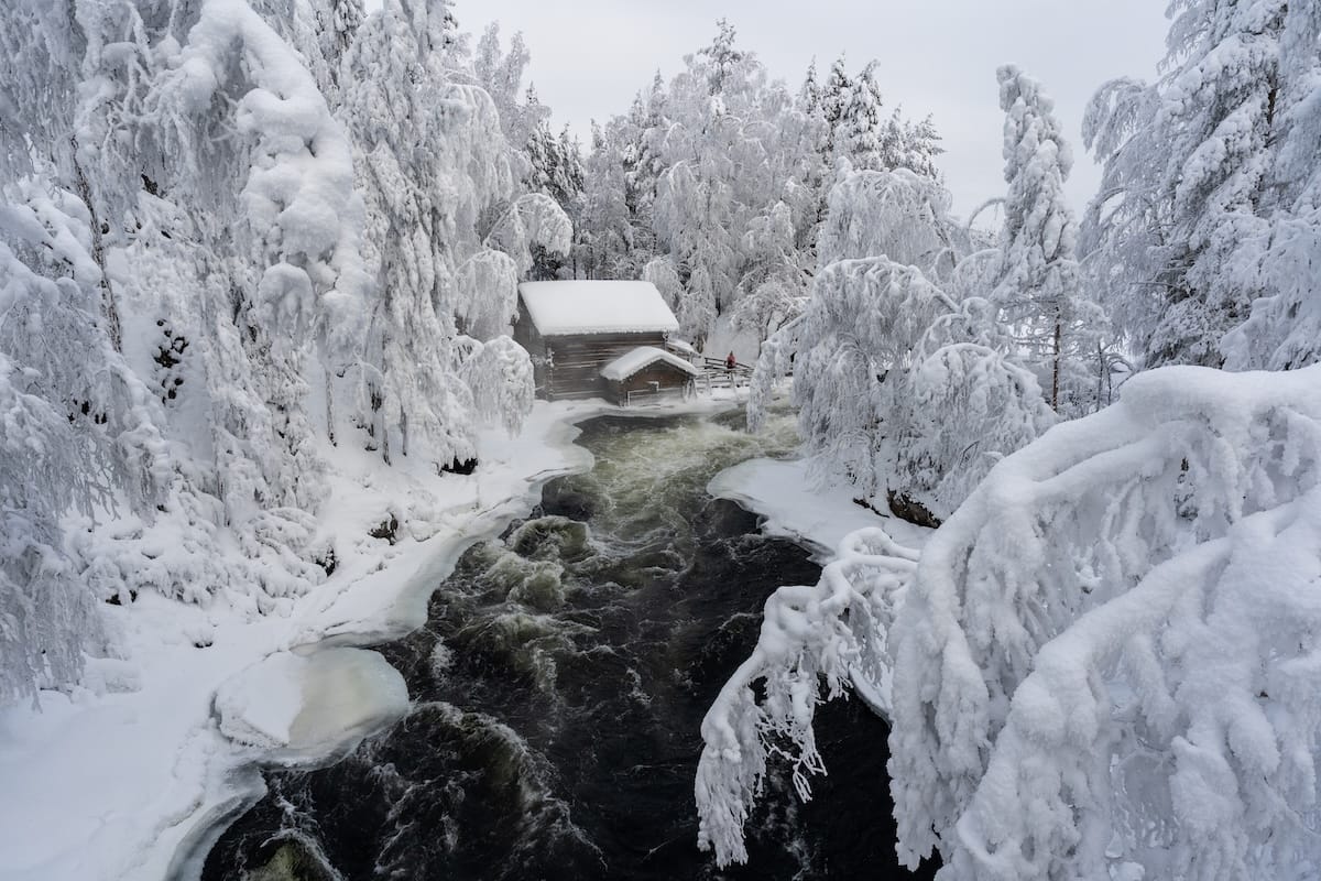An old wooden mill building on river rapids