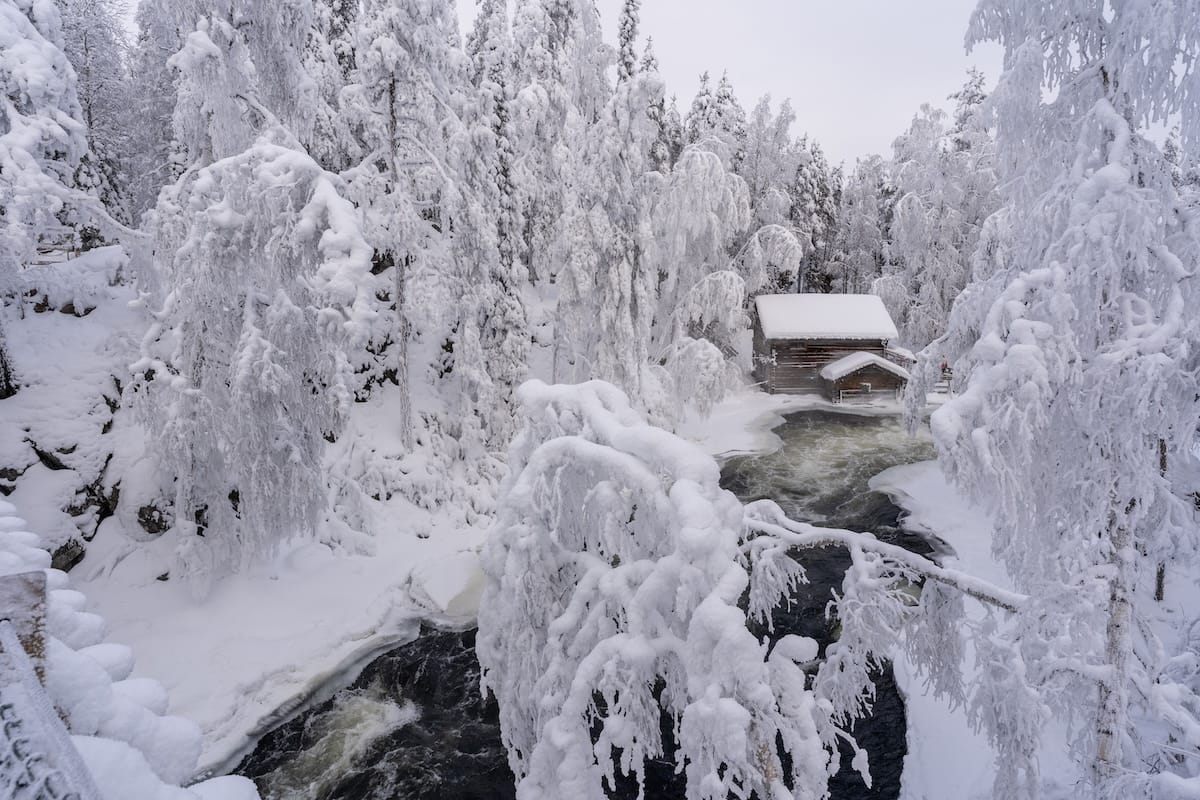 a photo of a mill on a river in a snowy landscape