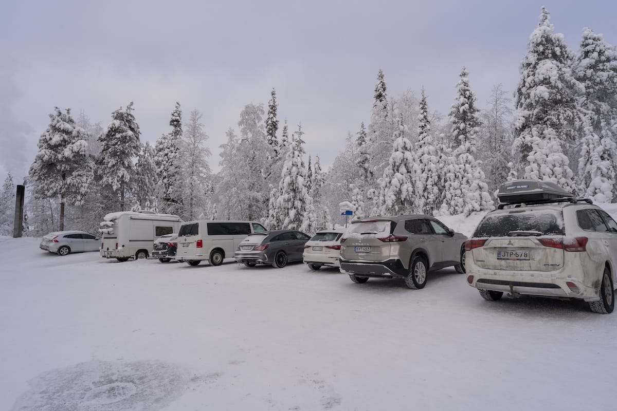 A parking lot with cars and snow coverage