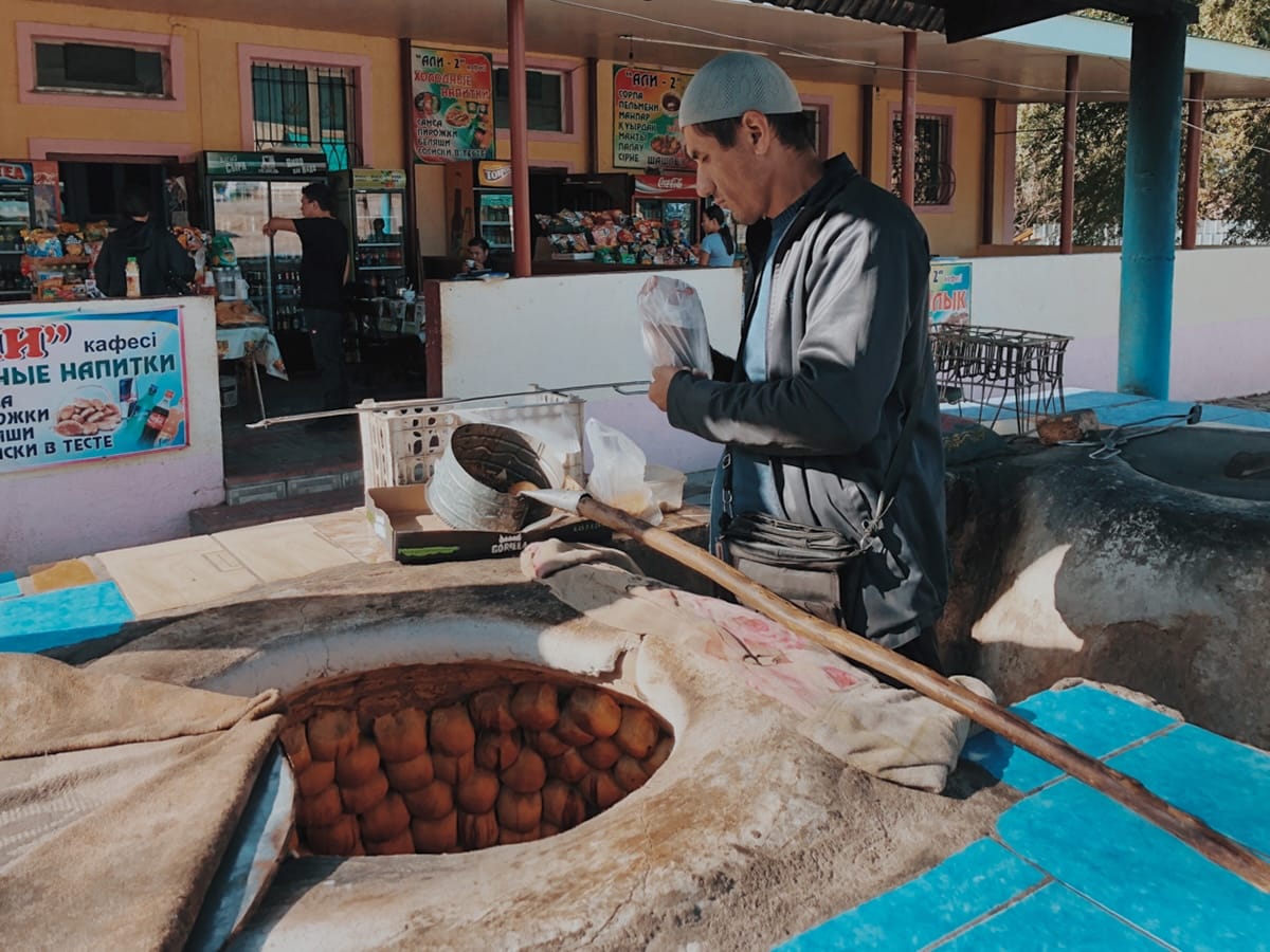 a man making samsas in a tandir
