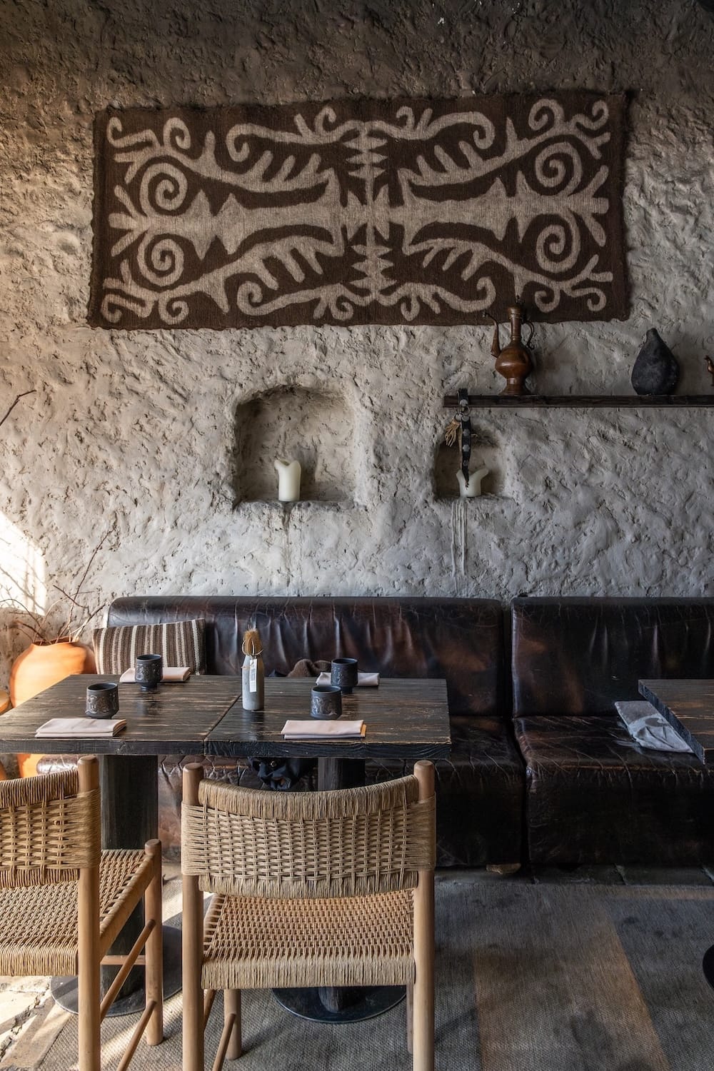 A table in a restaurant with felt decor on the wall
