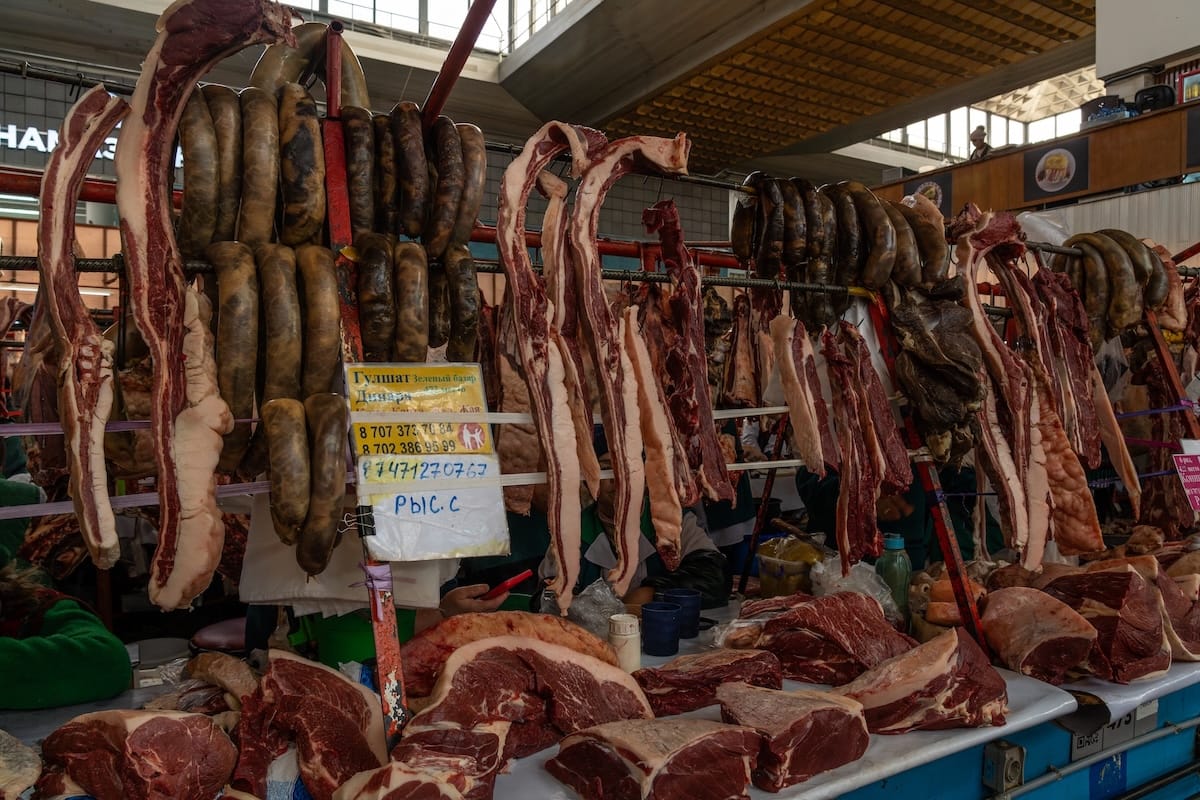 Kazy (horse sausage) alongside horsemeat at the Green Bazaar hanging from racks