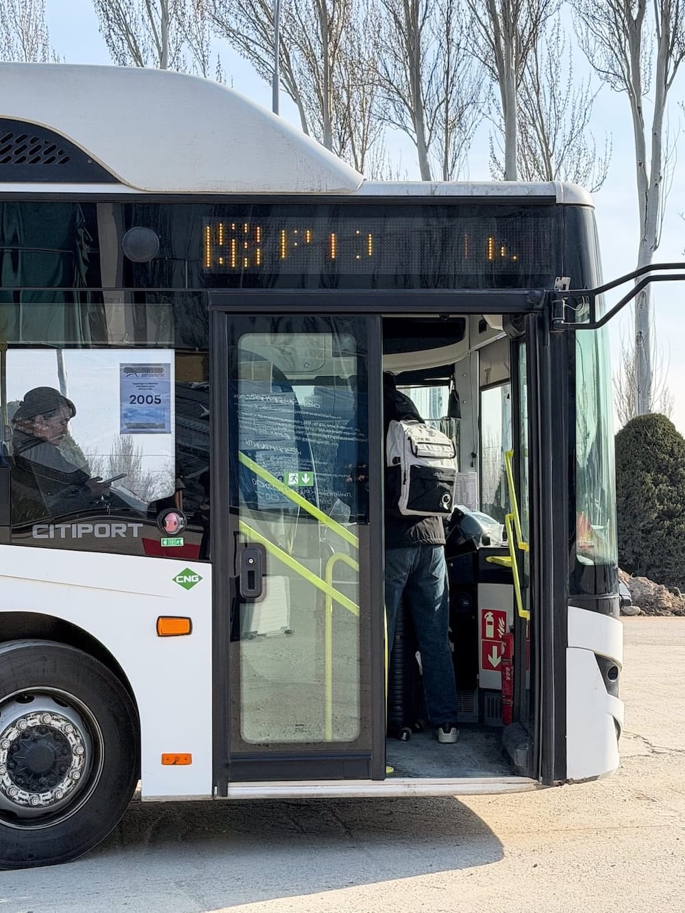 a white bus with people getting on it