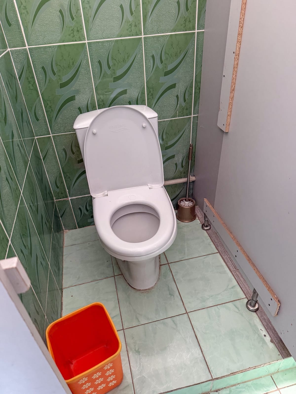 A toilet and a trashcan