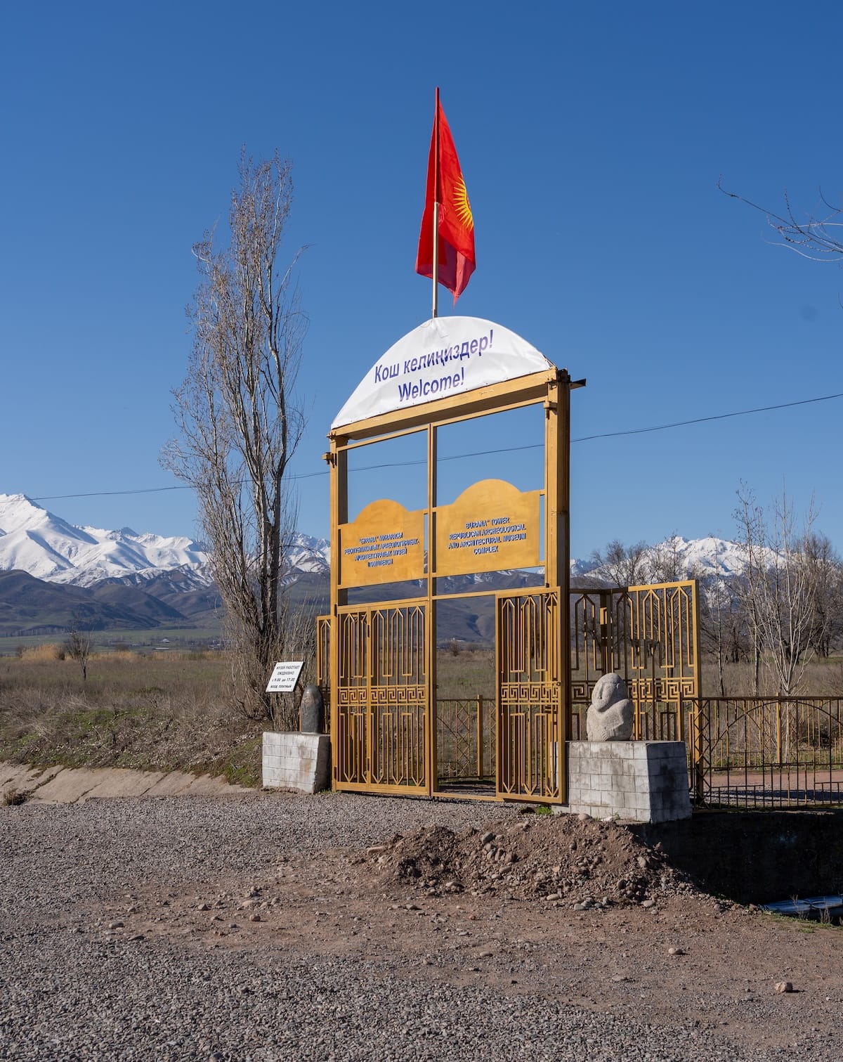 an entrance gate with a kyrgyz flag atop it