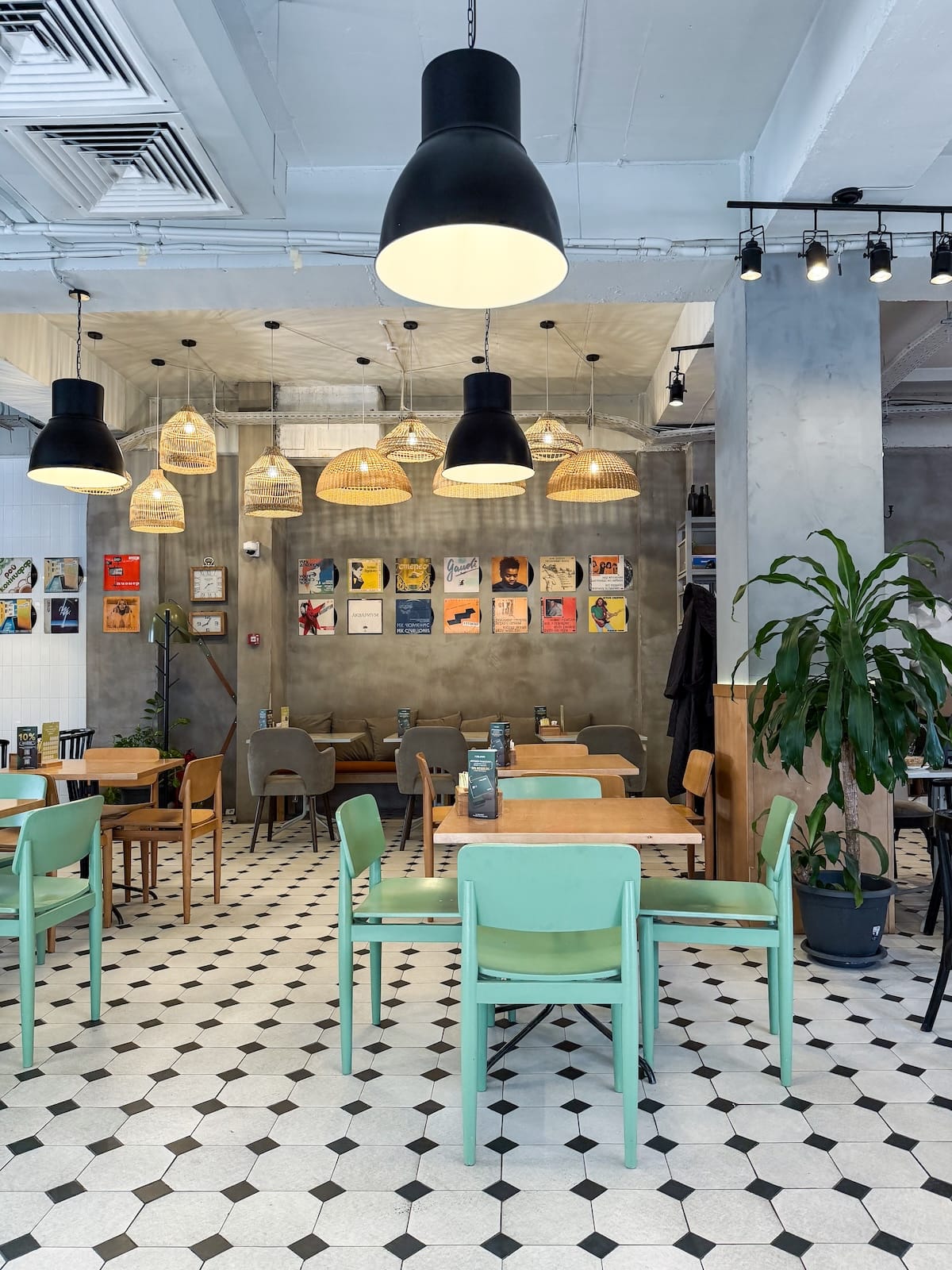 a cafe with beautiful decor, colorful chairs, artwork, and plants