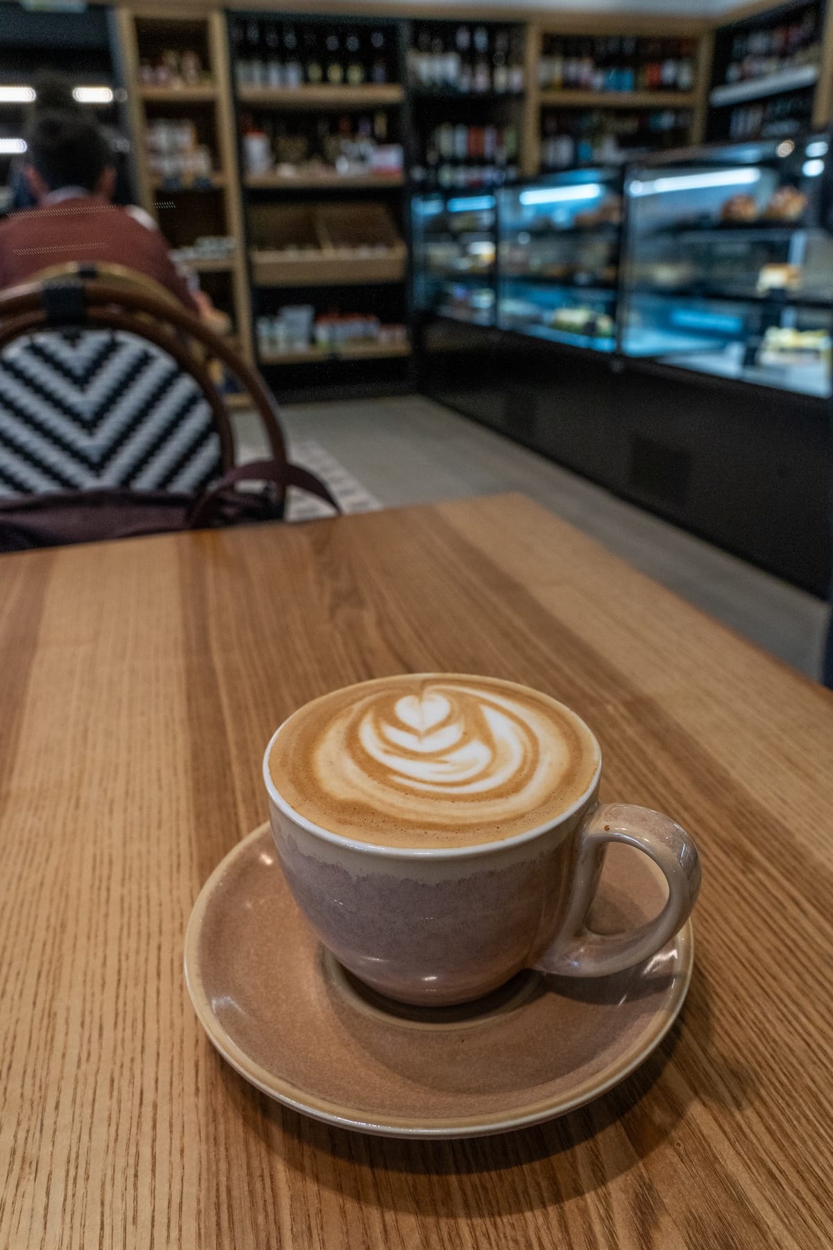 a flat white on a table with a black and white chair behind it