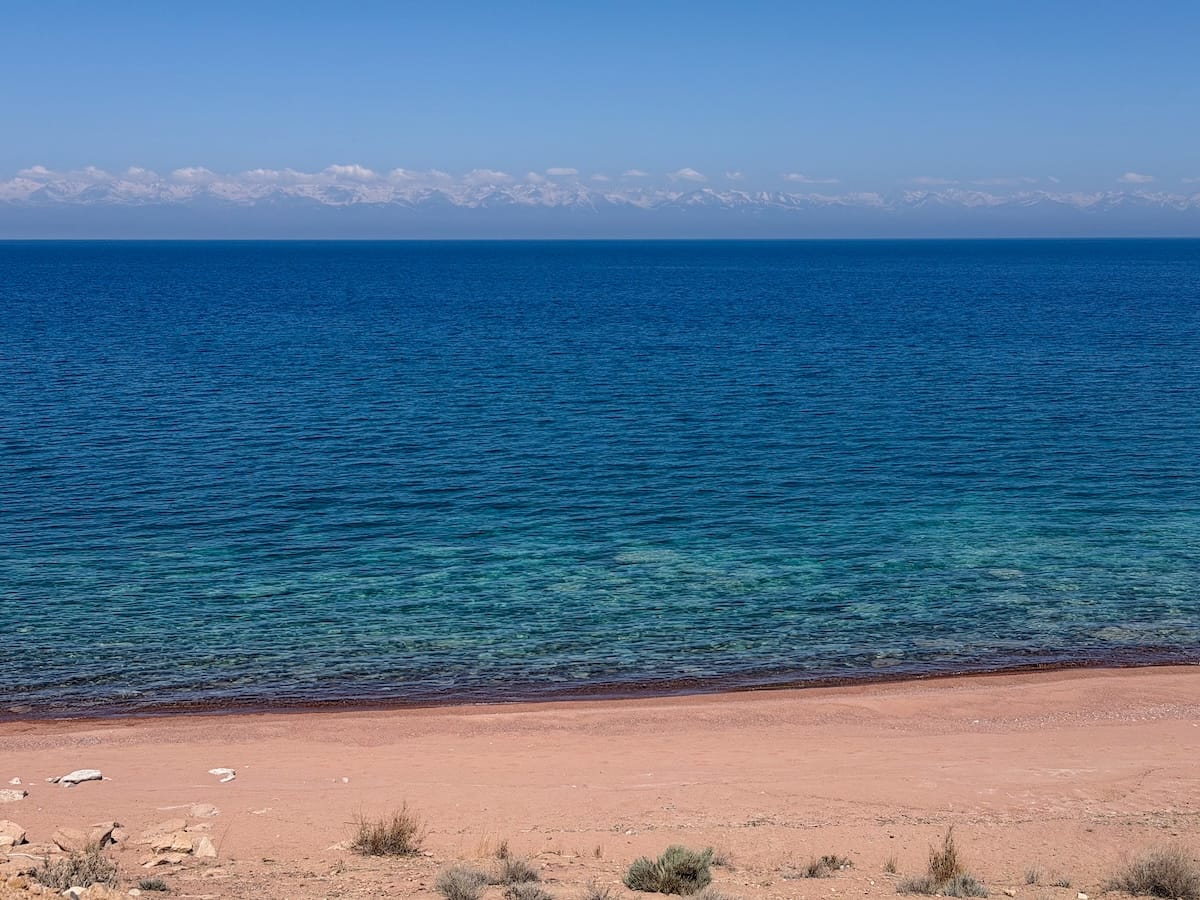 a photo of a lake with mountains in background