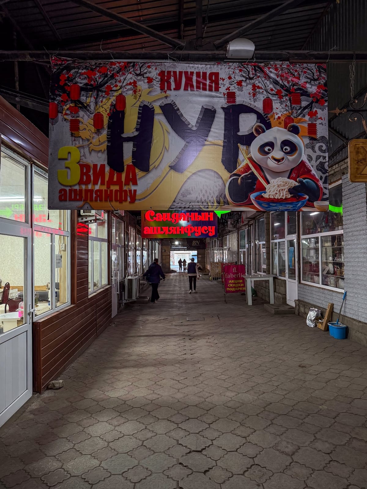 a picture of a dark walkway and signs hanging up