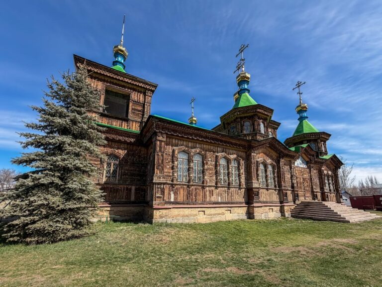 a wooden russian orthodox church with green golden domes