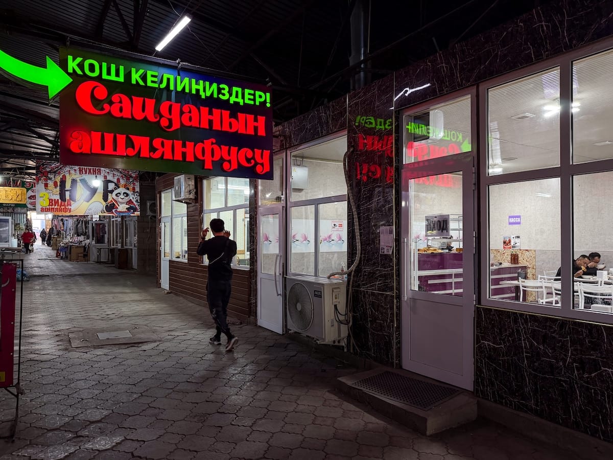 a photo of a neon sign in a dark walkway