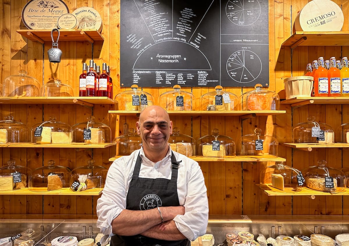 a man standing in front of his cheese shop