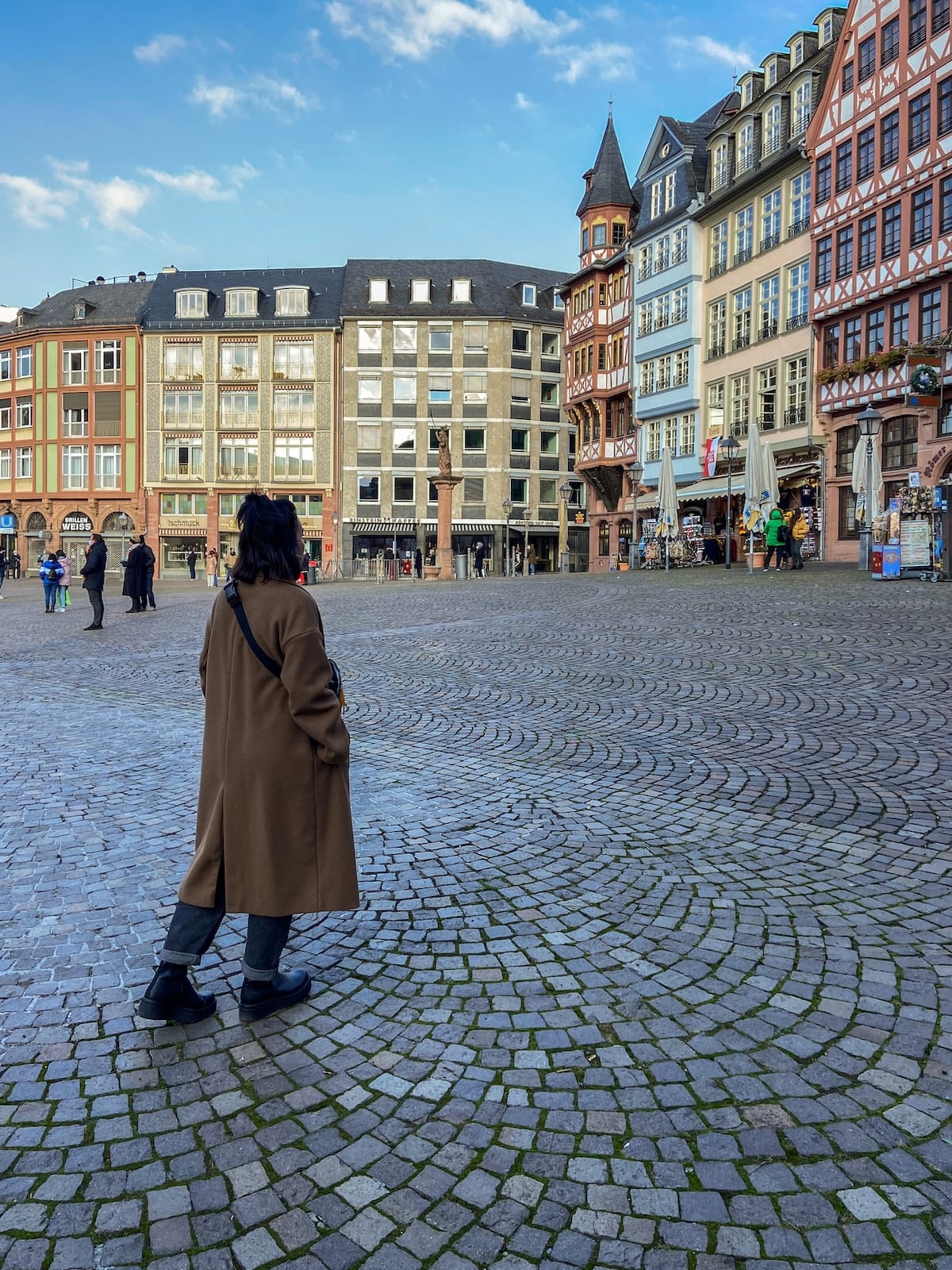 a woman standing in a historic square in germany