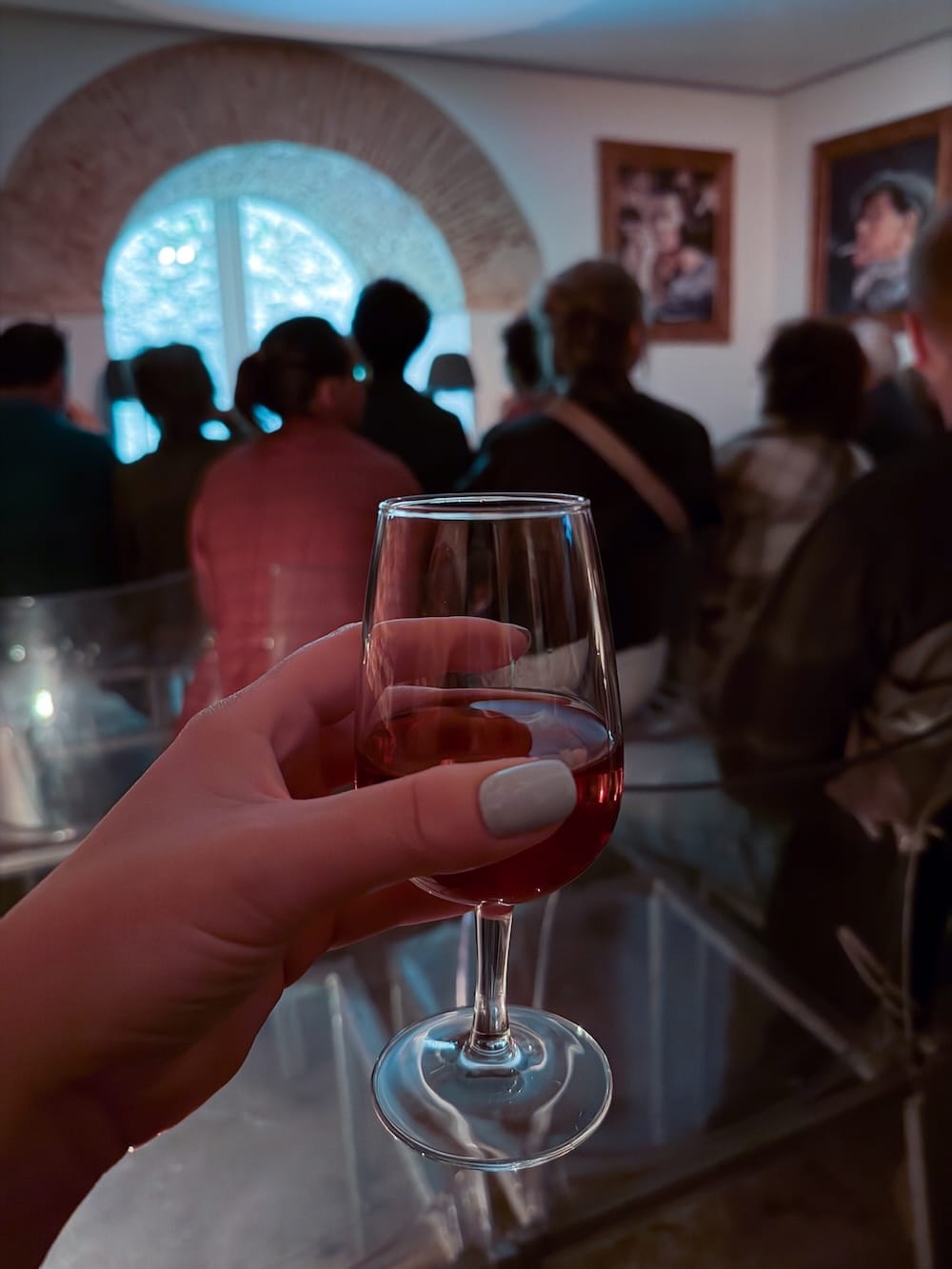 a womans hand with a glass in it at a fado show in lisbon