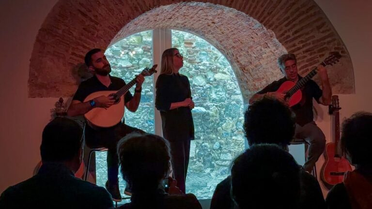 two guitarists and a singer on stage at a Fado show in Lisbon