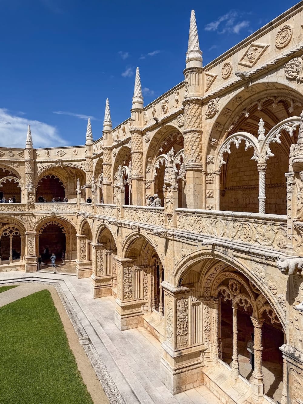 a monastery with blue skies and a green garden below