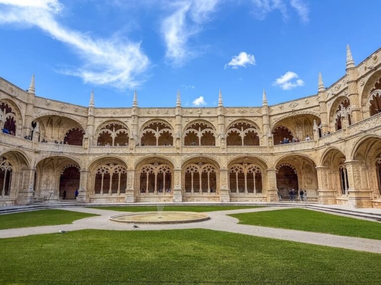 an old monastery with a green lawn in front of it