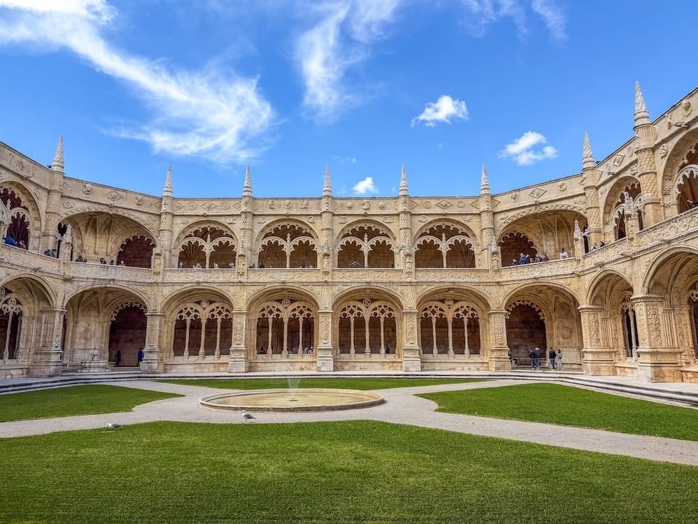 an old monastery with a green lawn in front of it