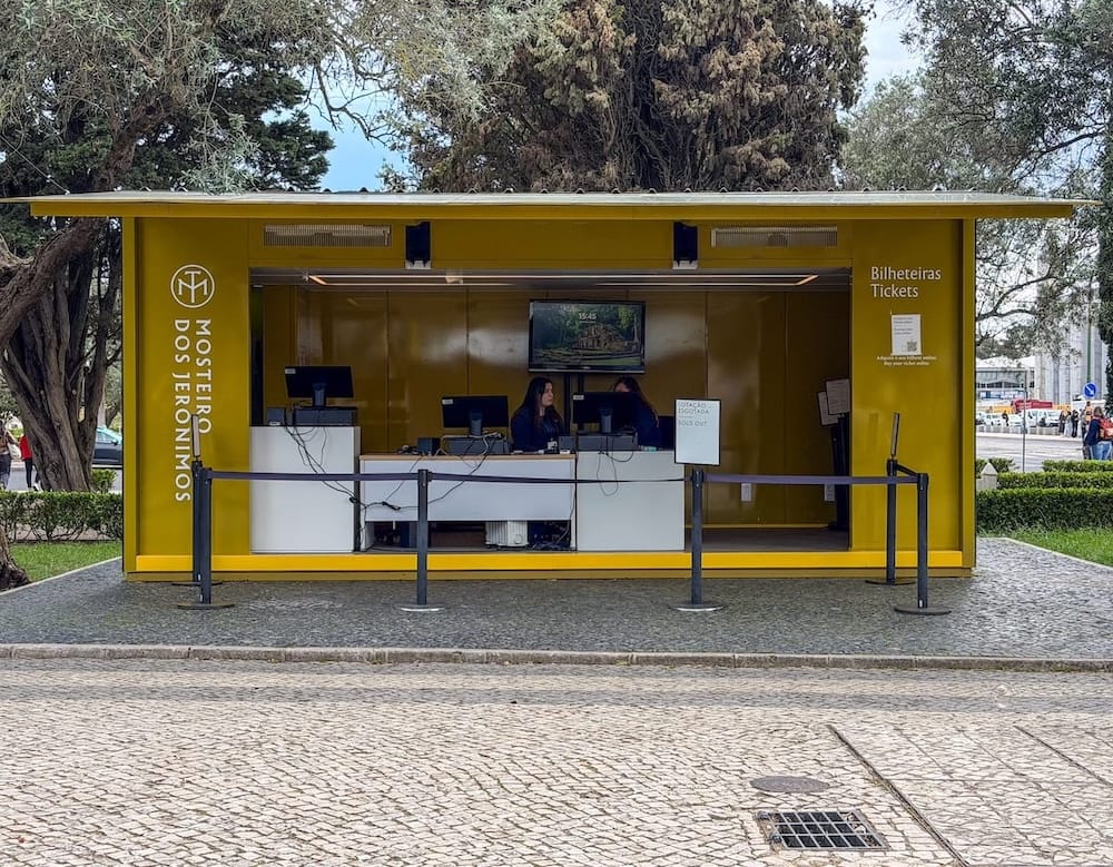 a yellow ticket booth under trees