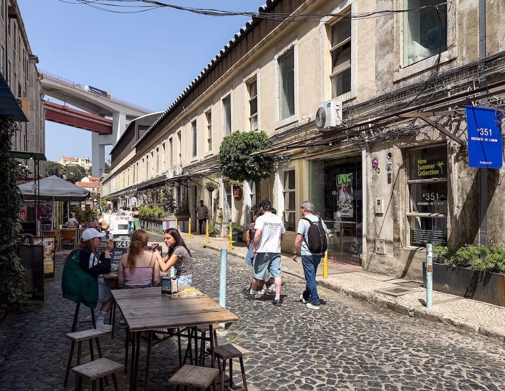 a photo of a cobblestone street between shops on both sides