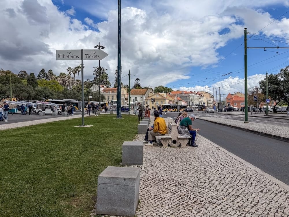 a road with people on a bench beside it