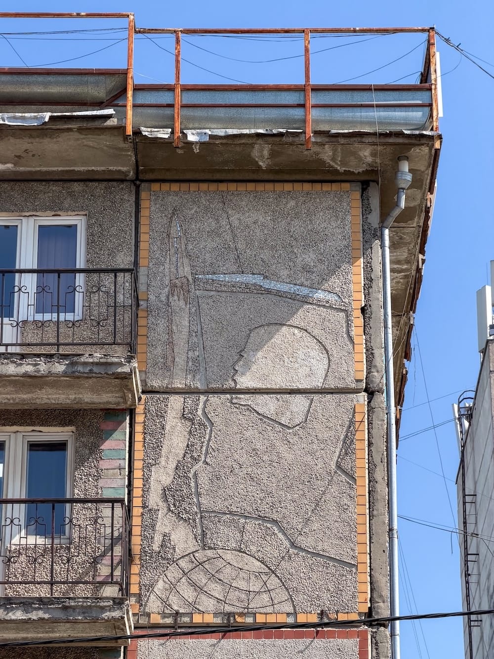 an sgraffito of Lenin's head along with a few others on a concrete building