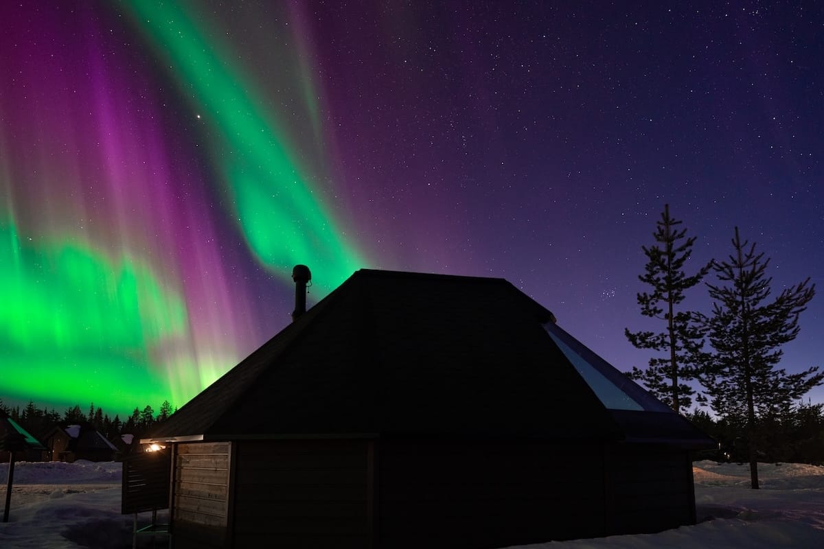 glass igloo under colorful northern lights