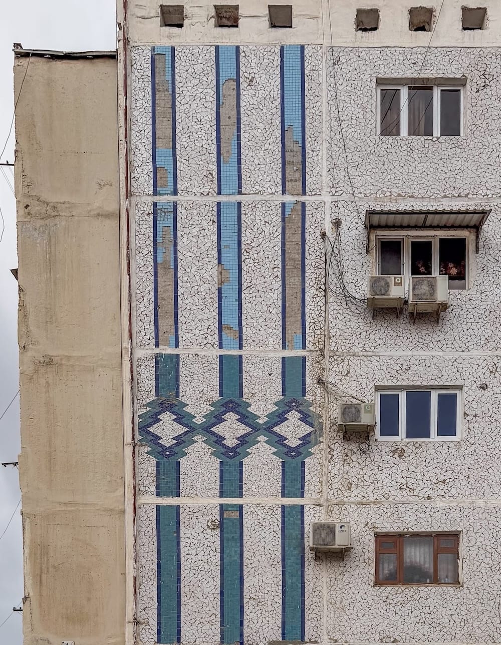 a blue mosaic of stripes on a building