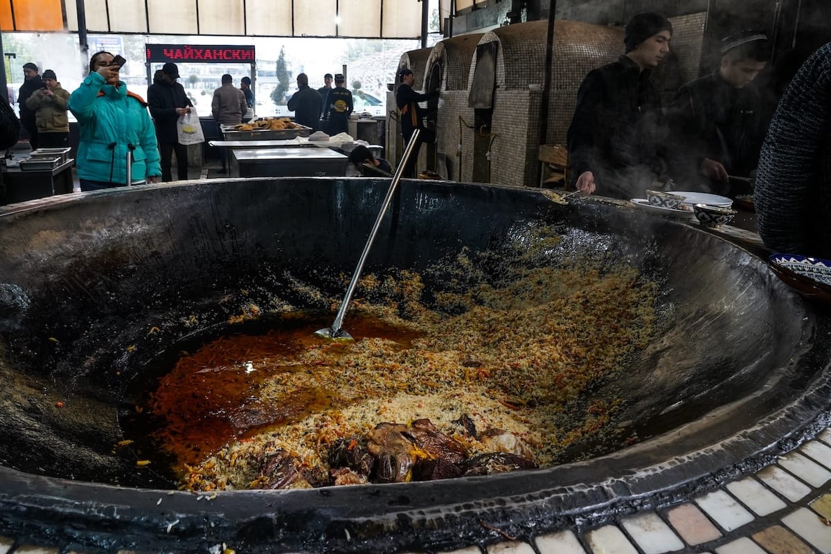 a huge kazan filled with plov and oil in a restaurant