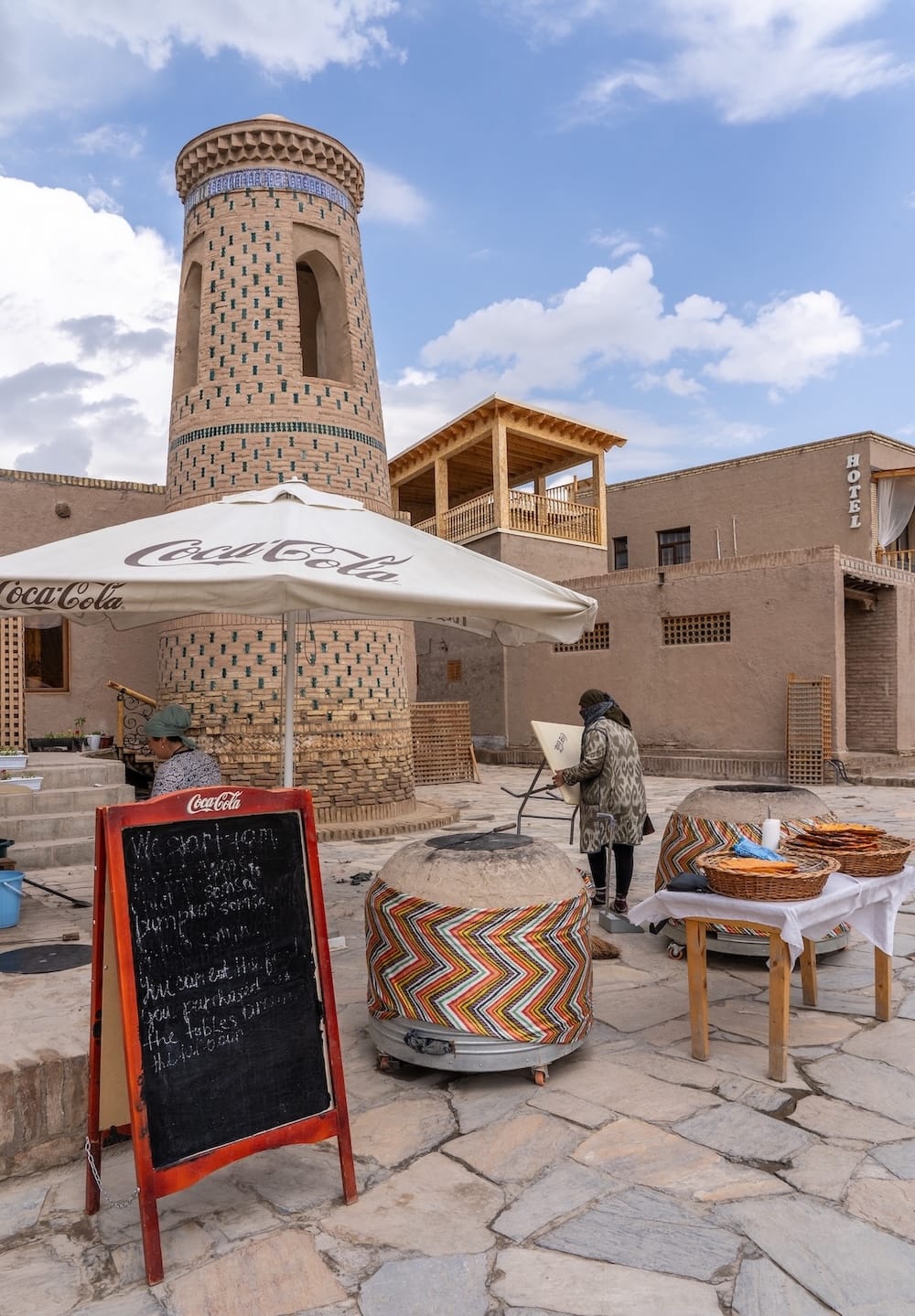 a small bakery outside a minaret with a sign and tandir
