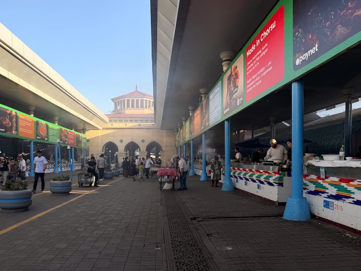 a busy bazaar in tashkent with many stalls lining both sides