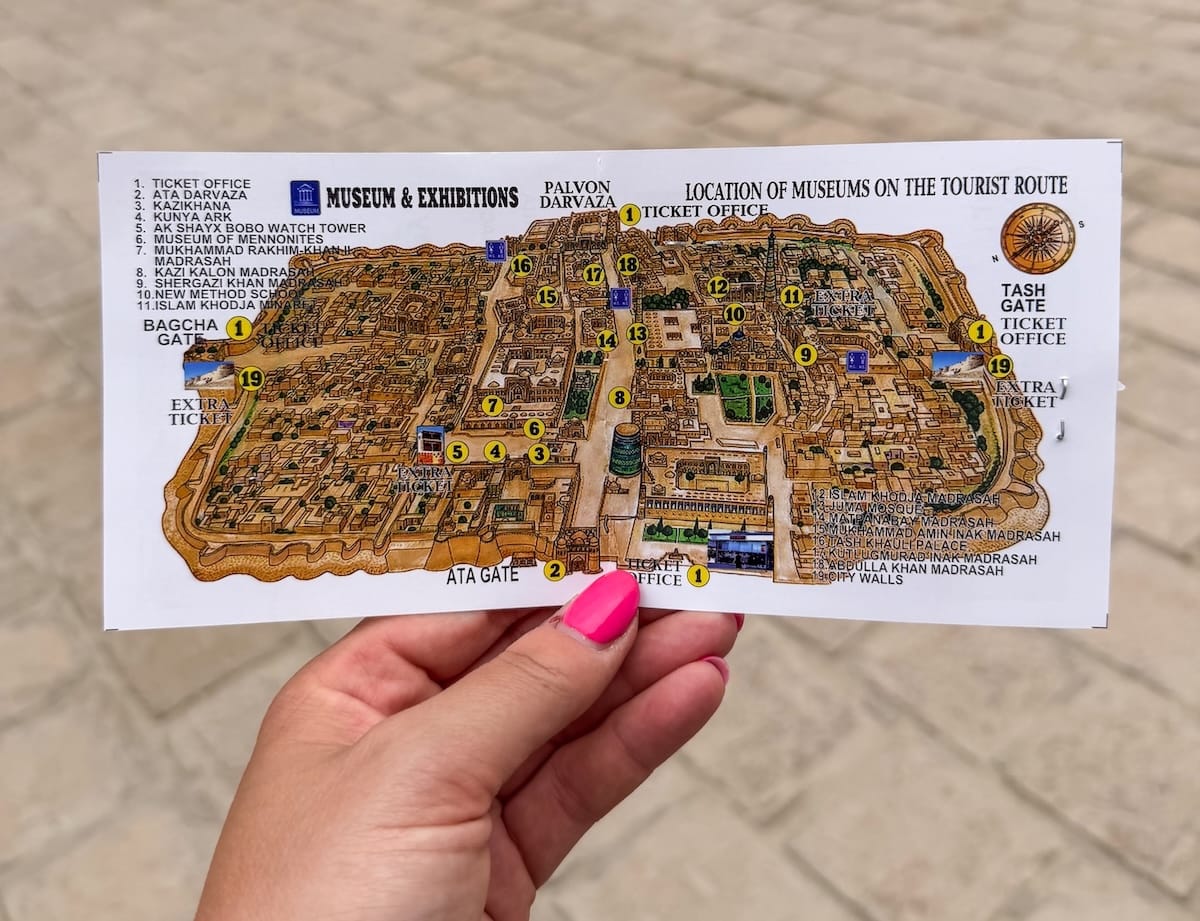 a woman's hand with a ticket with sites in khiva, uzbekistan on it