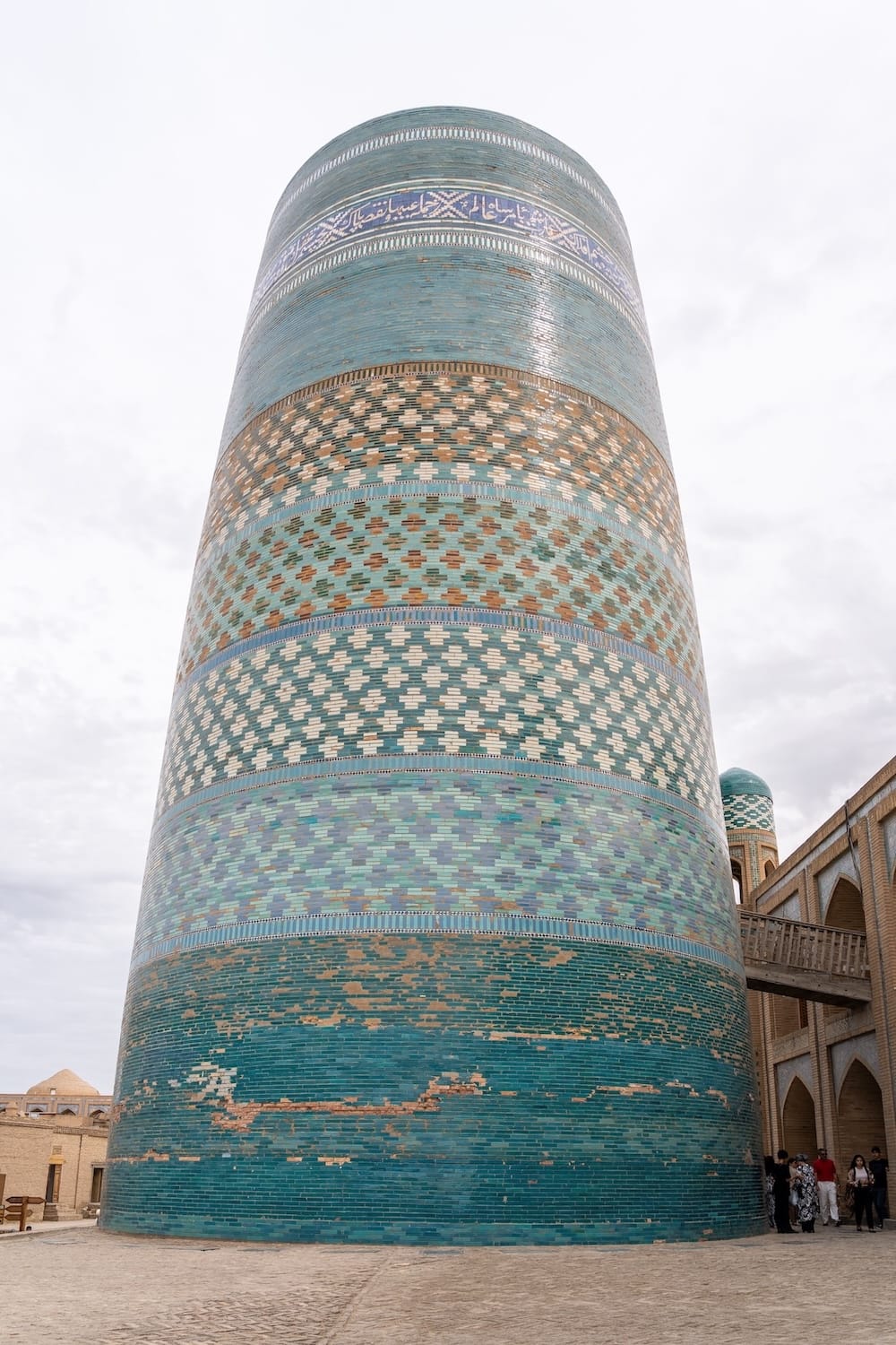a large, teal and blue tiled minaret in khiva, uzbekistan