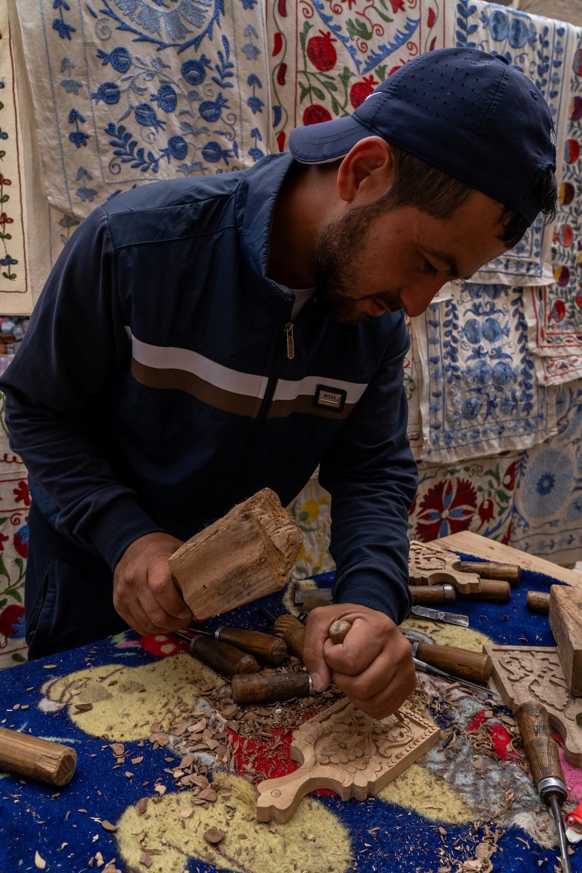 a man chiseling away at a wooden mini cutting board