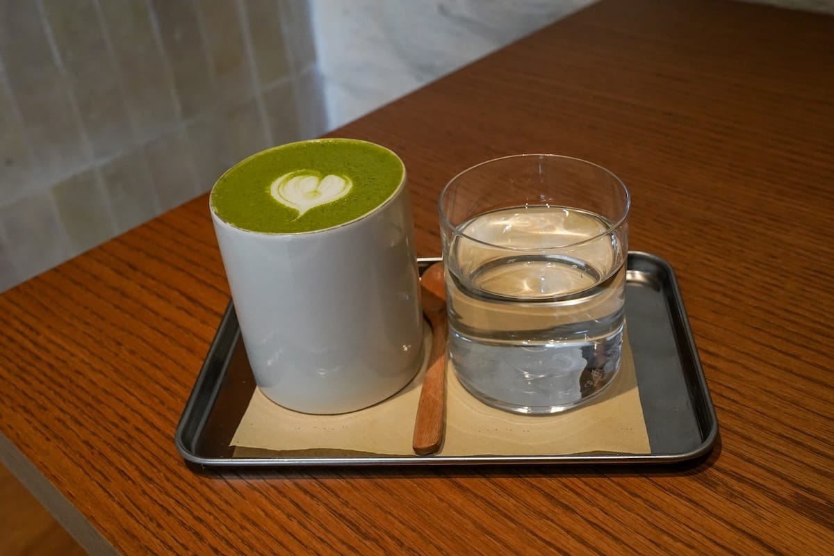 a matcha and a glass of water on a table