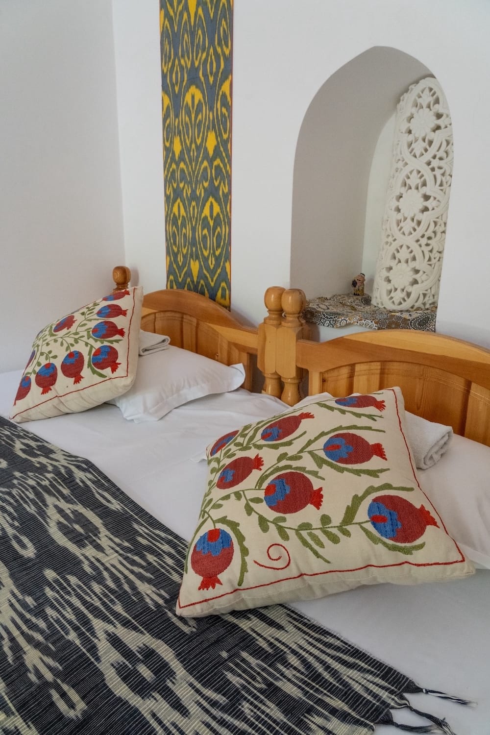 an upclose shot of the bed in my room with two pillows with pomegranates on them
