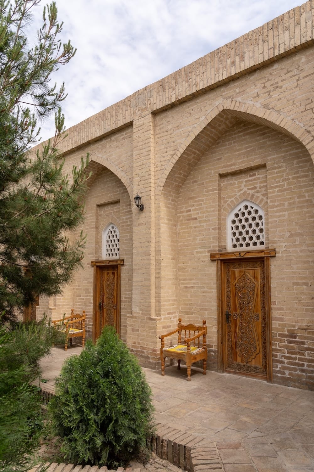 inside a courtyard of a madrasah turned hotel - two rooms with doors