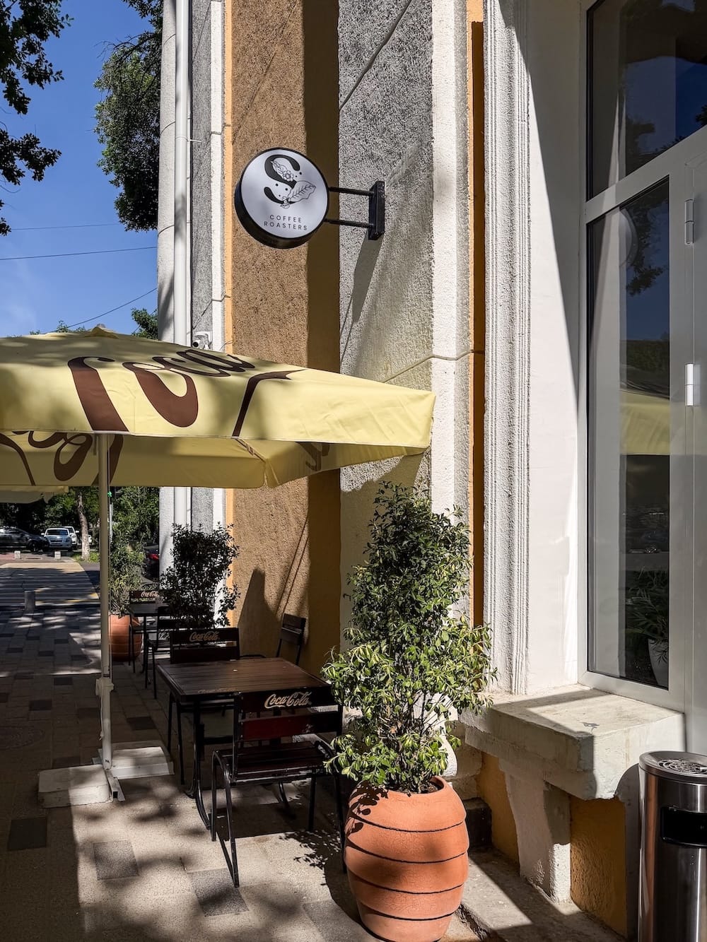 outside a coffee shop with a terrace and umbrellas