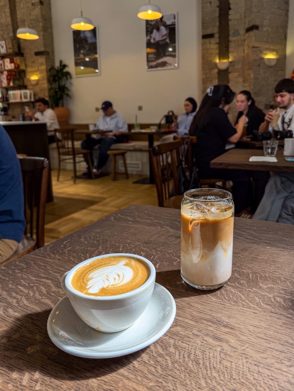a flat white and an ice latte on a table in a coffee shop