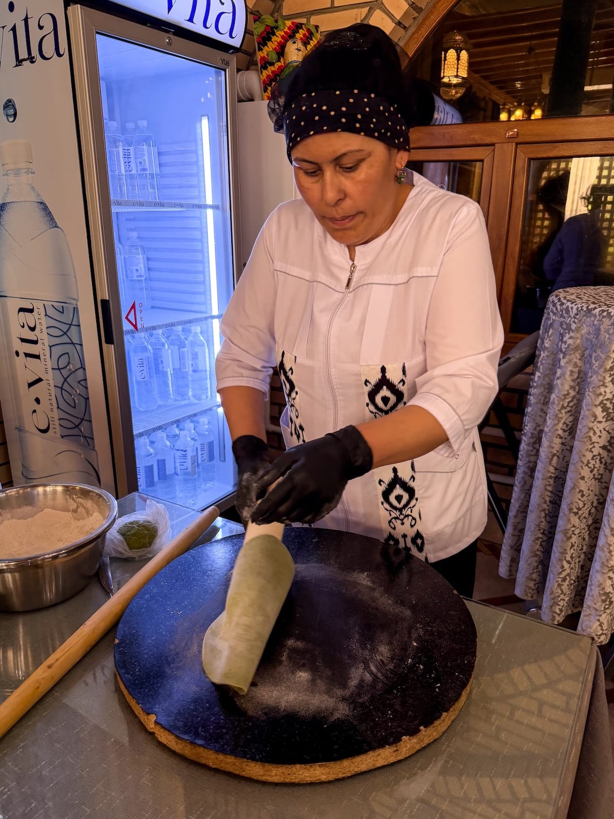 a woman making green dill noodles in a kitchen in uzbekistan