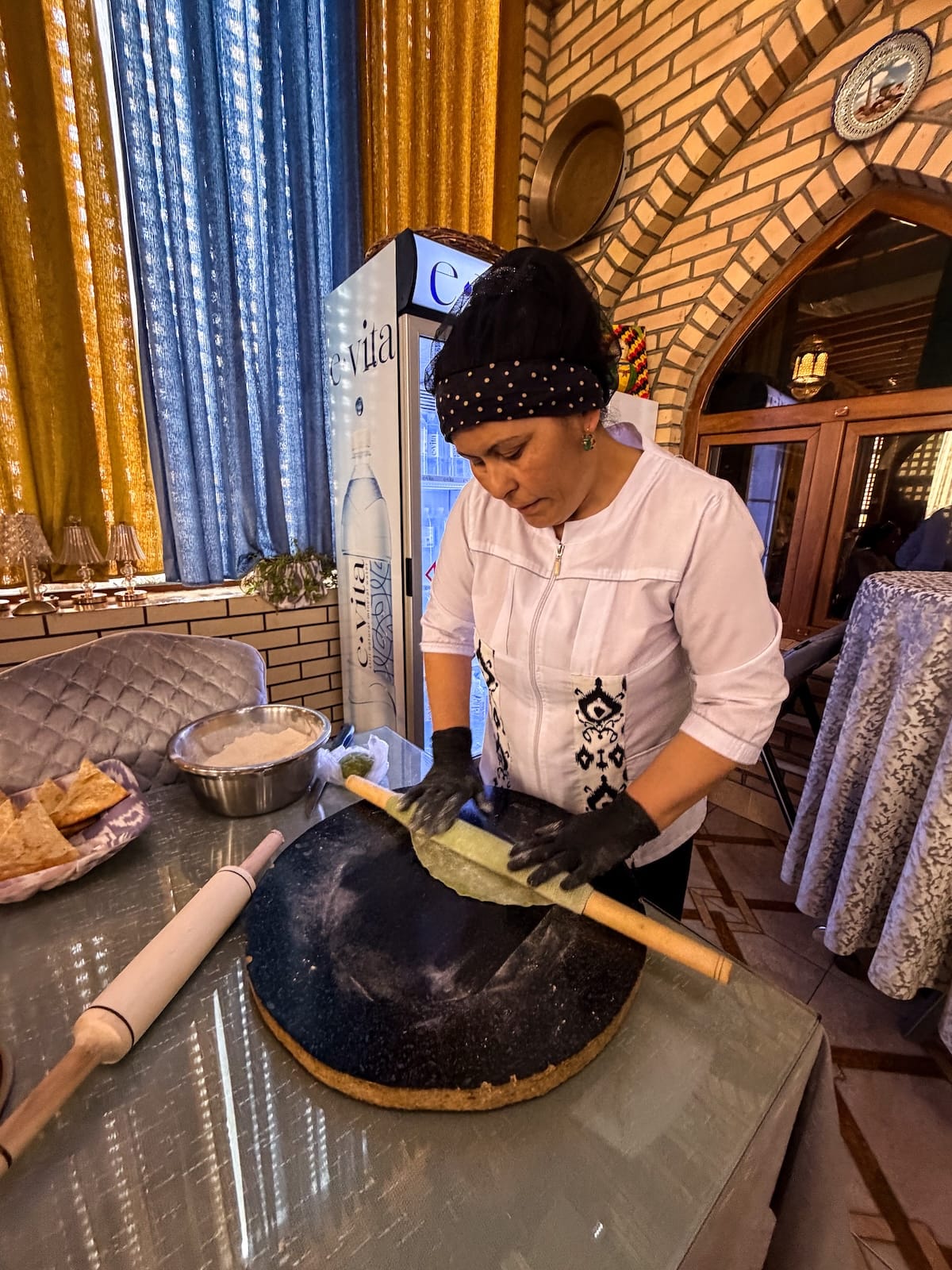 a woman with a rolling pin and green dough for pasta