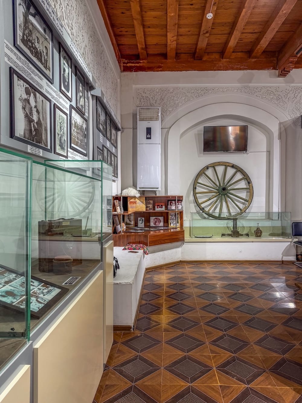 inside an exhibit with artifacts on the wall and a tiled floor